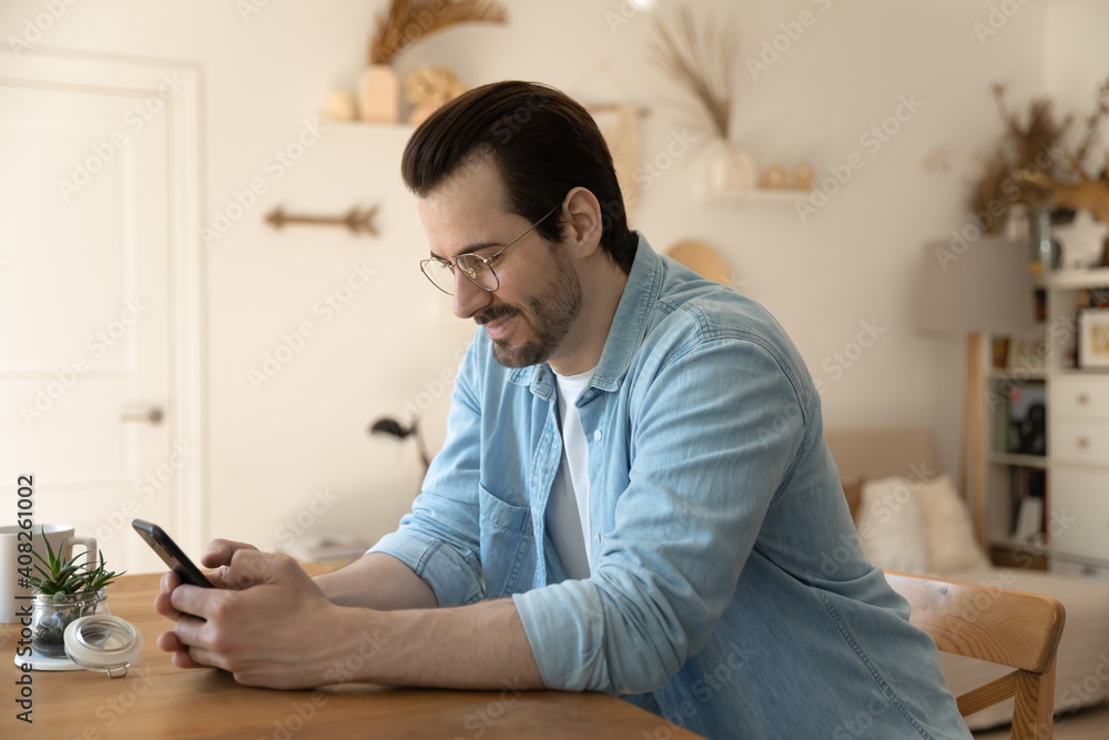 Web mining. Concentrated millennial male stay at home on weekend engaged in playing mobile game on cellphone screen. Focused young guy browsing web enjoying chatting online using social media apps Web mining. Concentrated millennial male stay at home on weekend engaged in playing mobile game on cellphone screen. Focused young guy browsing web enjoying chatting online using social media apps