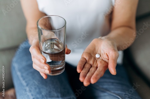 Photos Top view of female hands with pill and water