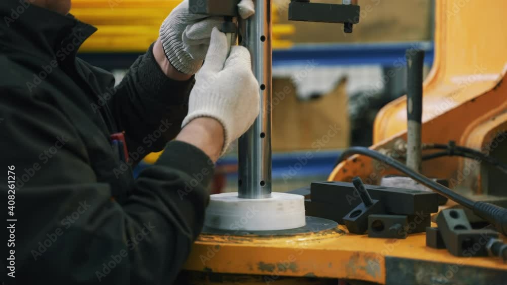 The mechanic tightens the nut. He attaches the boring shaft. The mechanic tightens the nut. He attaches the boring shaft.