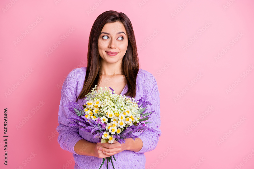 Photo of optimistic girl hold flowers look empty space wear lilac sweater isolated on pink color background Photo of optimistic girl hold flowers look empty space wear lilac sweater isolated on pink color background