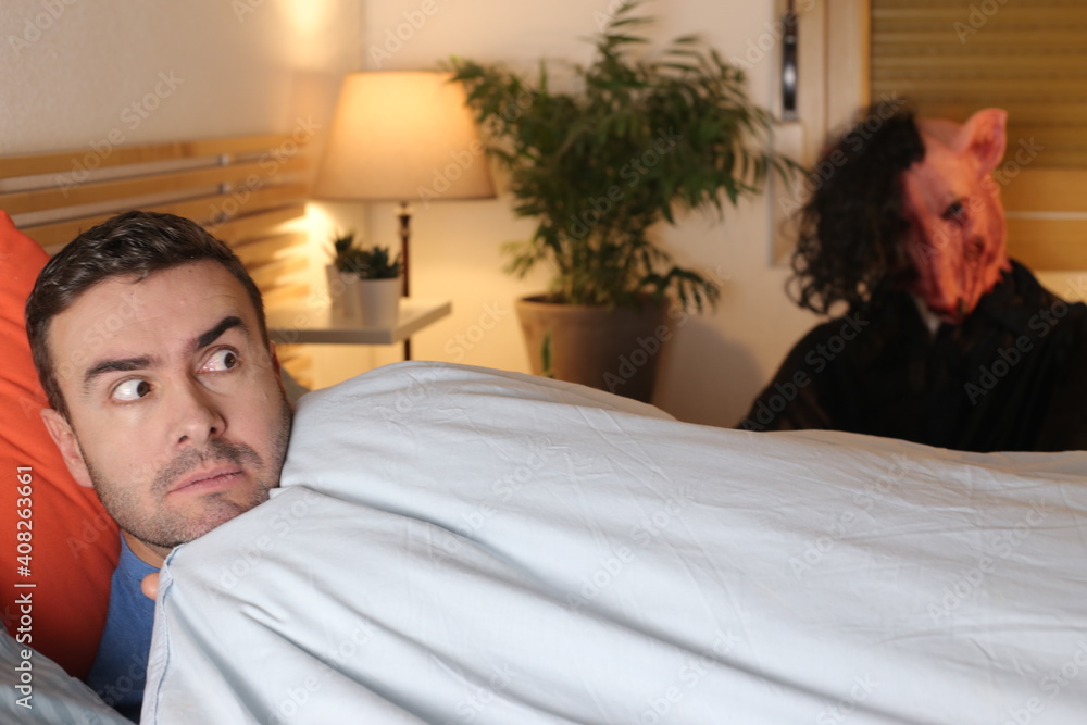 Fototapeta premium Terrified man seeing a monster in his bedroom