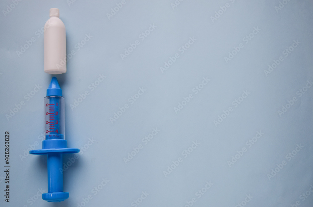 Child medicine tools. Vaccination COVID19. Blue syringe with vaccine on blue background. Concept vaccination children on coronavirus. Child medicine tools. Vaccination COVID19. Blue syringe with vaccine on blue background. Concept vaccination children on coronavirus.
