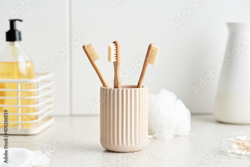 Cup with eco friendly toothbrushes near hygienic supplies