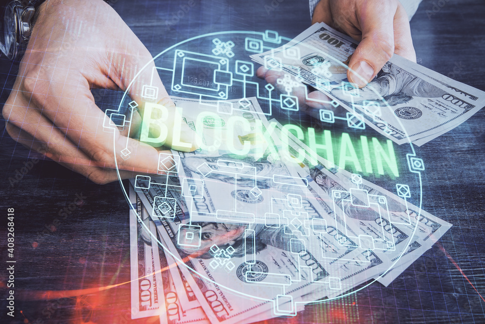 Multi exposure of blockchain theme drawing hologram and USA dollars bills and man hands. Business concept. Multi exposure of blockchain theme drawing hologram and USA dollars bills and man hands. Business concept.
