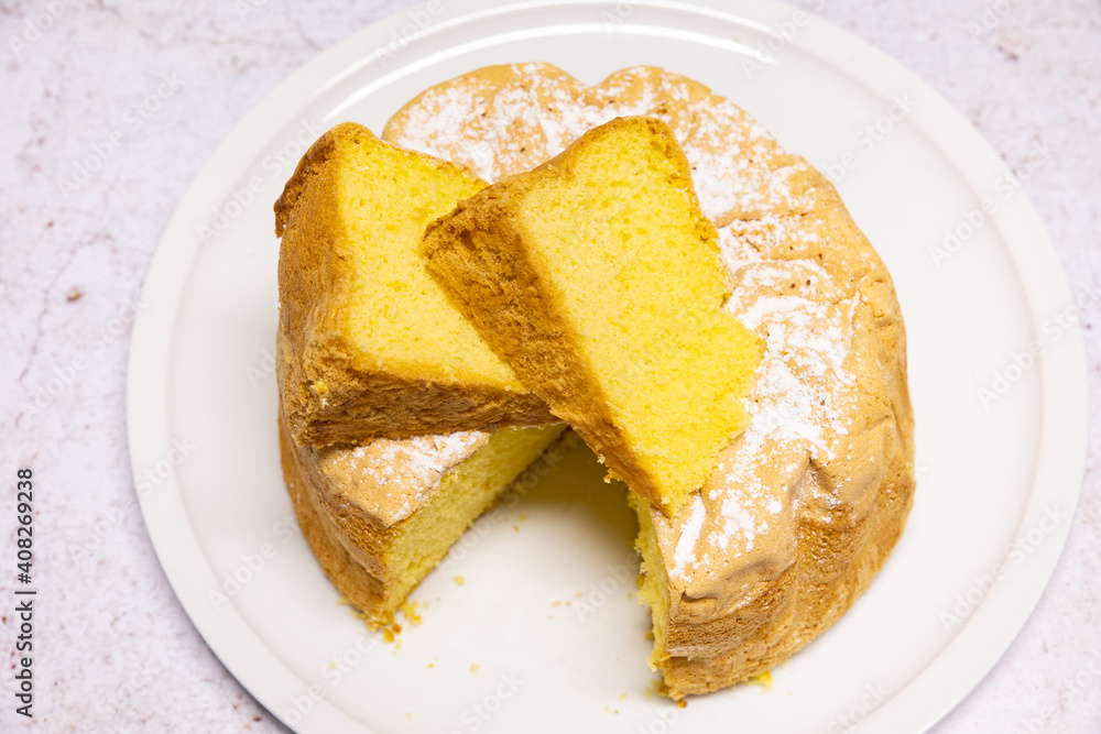 Homemade Savoie cake on a pretty white porcelain dish Homemade Savoie cake on a pretty white porcelain dish