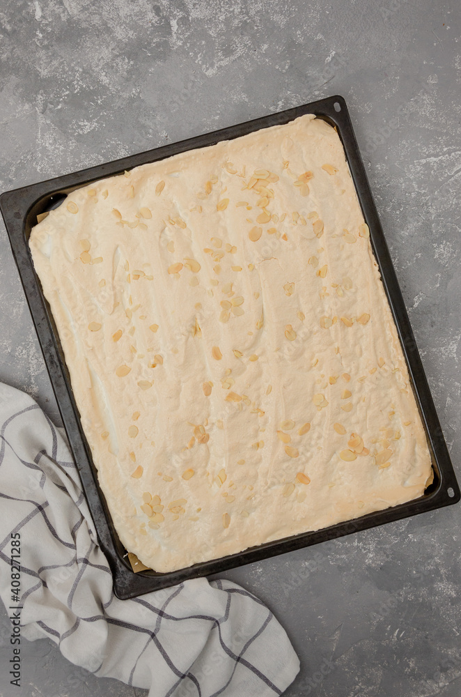 Cooking meringue Pavlova roll cake. Baked meringue on a baking sheet on a gray concrete background. Recipe step by step. Vertical, Top view. Cooking meringue Pavlova roll cake. Baked meringue on a baking sheet on a gray concrete background. Recipe step by step. Vertical, Top view.