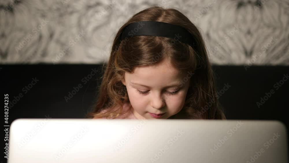 Portrait young girl holding laptop. Lass using computer at home. Adorable six year old 6 miss sitting with notebook. Close-up Portrait young girl holding laptop. Lass using computer at home. Adorable six year old 6 miss sitting with notebook. Close-up