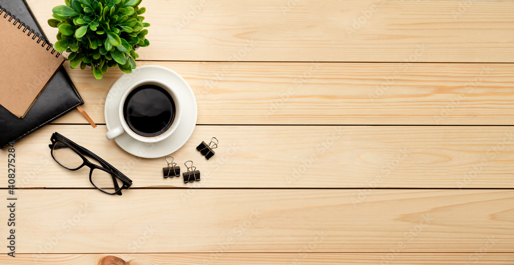 Top view office table desk. Workspace with blank, office supplies, pencil, green leaf, and coffee cup on wood background. Top view office table desk. Workspace with blank, office supplies, pencil, green leaf, and coffee cup on wood background.