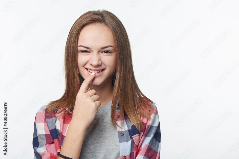 Playful girl inventing some prank biting her finger