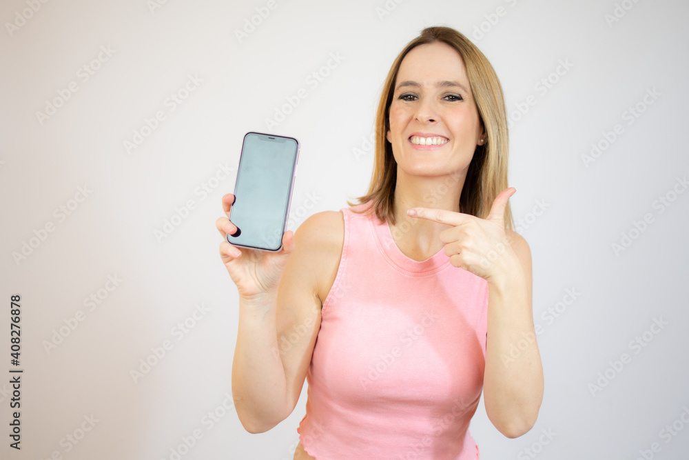 Portrait of a smiling young casual woman showing mobile phone isolated over white background Portrait of a smiling young casual woman showing mobile phone isolated over white background