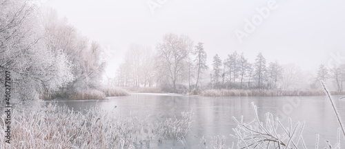 Fotografie, Obraz Frozen lake in snowy forest landscape