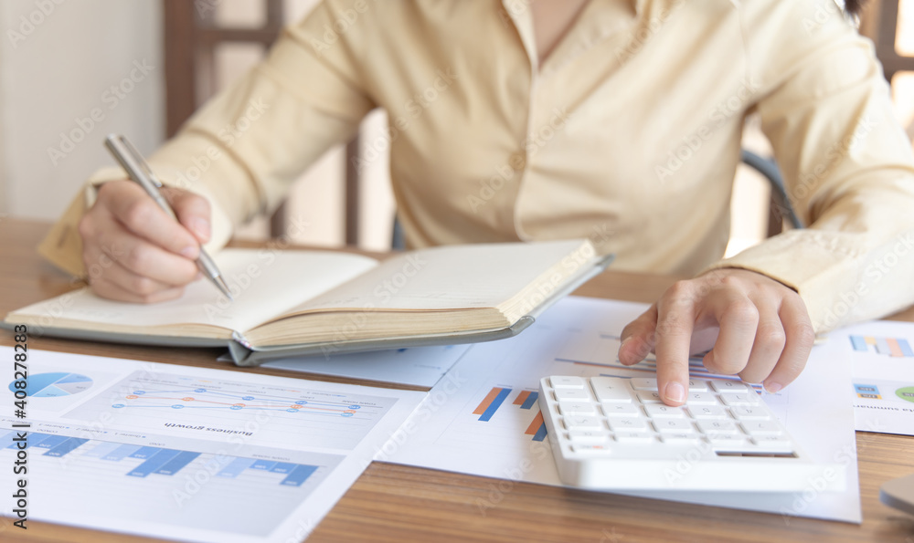 Head of accounting is recording the company's financial growth statistics using graphs as a reference for reviewing and analyzing the results, Taking notes and analyzing data graphs in office. Head of accounting is recording the company's financial growth statistics using graphs as a reference for reviewing and analyzing the results, Taking notes and analyzing data graphs in office.