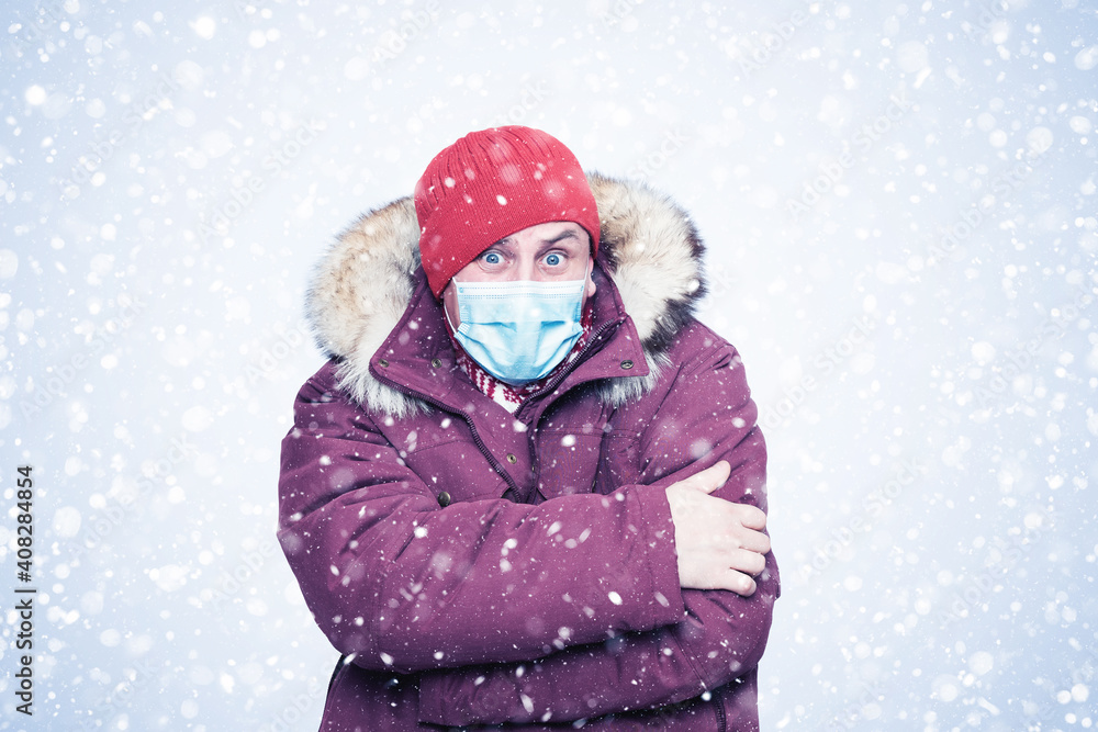 Frozen man in red winter clothes on his face wearing a respirator mask to protect against the virus covid, snow around Frozen man in red winter clothes on his face wearing a respirator mask to protect against the virus covid, snow around