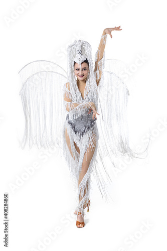 Dancing. Beautiful young woman in carnival, stylish masquerade costume with feathers dancing on white studio background. Concept of holidays celebration, festive time, dance, party, fashion