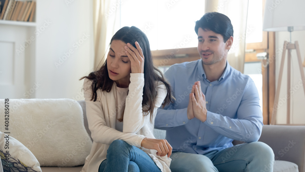 Husband asking forgiveness, making peace with offended annoyed wife after quarrel or cheating, young woman ignoring man, not talking, family crisis, relationship problem, break up and divorce Husband asking forgiveness, making peace with offended annoyed wife after quarrel or cheating, young woman ignoring man, not talking, family crisis, relationship problem, break up and divorce