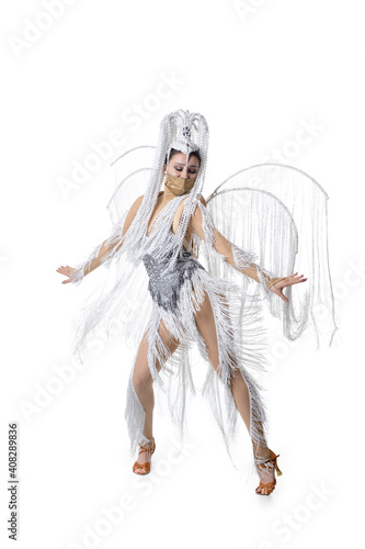 Posing. Beautiful young woman in carnival, stylish masquerade costume with feathers and golden face mask on white background. Concept of holidays celebration, festive time, dance, party, fashion