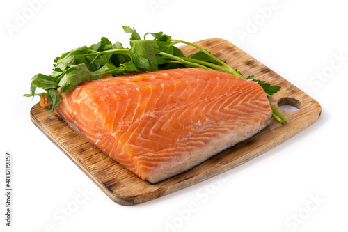Raw salmon fillet and parsley on cutting board isolated on white background