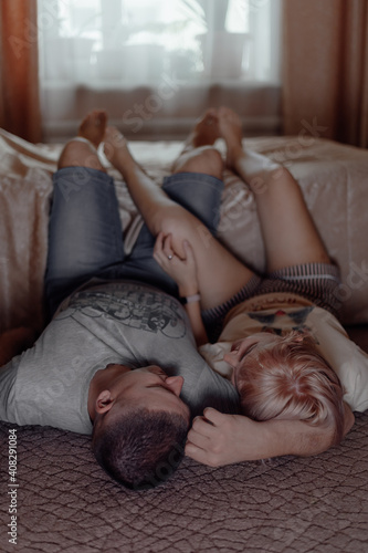 Happy young couple looking at each other and smiling while lying on floor. The concept of celebrating Valentine's Day. Love and relationships