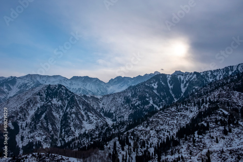 Winter snowy Tien-Shen mountains in morning background. Adventure tourism. Beautiful nature landscape. Winter mountain forest.