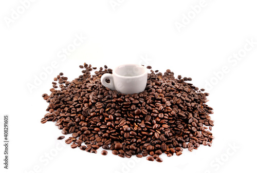 White cup on saucer in coffee beans on white background