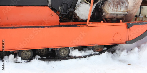 Old Russian utility snowmobile roller crawler drive gear with snow close up