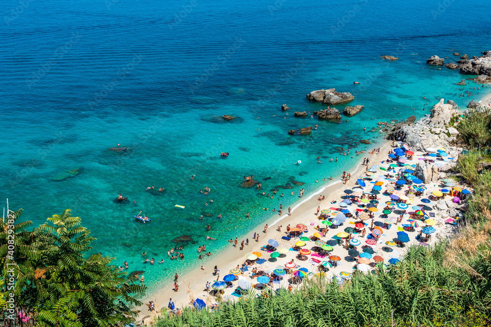 Michelino beach in Parghelia near Tropea during summertime, Calabria, Italy. Sandy beach full of vacationers and colorful umbrellas