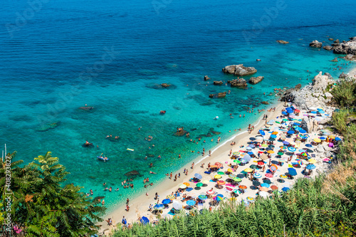 Michelino beach in Parghelia near Tropea during summertime, Calabria, Italy. Sandy beach full of vacationers and colorful umbrellas photo