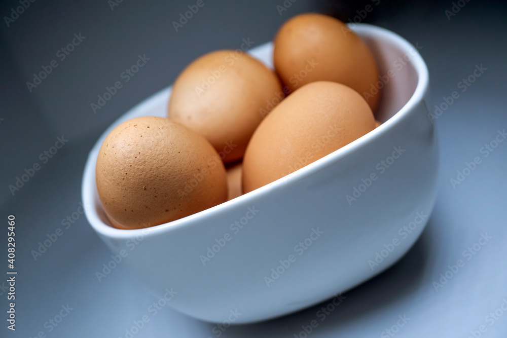 White bowl of brown, speckled, chicken eggs, isolated, macro White bowl of brown, speckled, chicken eggs, isolated, macro