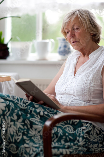 Seniorin lesend im Sessel