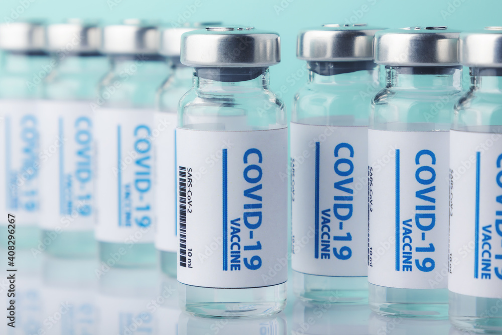 Ampoules with Covid-19 vaccine on blue background. Coronavirus sars-cov-2 pandemic. Ampoules with Covid-19 vaccine on blue background. Coronavirus sars-cov-2 pandemic.