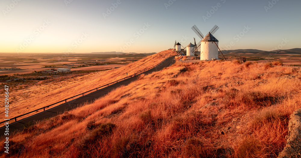 Windmills situed in Castilla la Mancha, Spain, captured during sunrise. - obrazy, fototapety, plakaty 