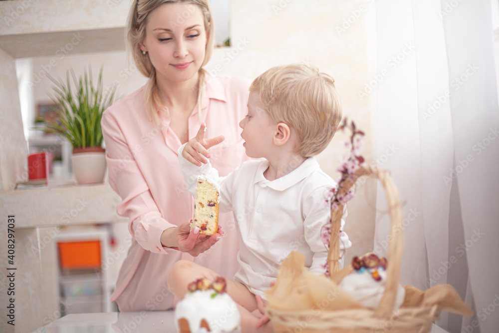 The kid eating traditional russian easter cake on table. The decorarion of kulich are the flower are cooking for spring holiday The kid eating traditional russian easter cake on table. The decorarion of kulich are the flower are cooking for spring holiday