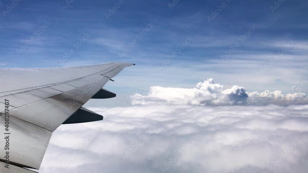 POV airplane overlooking beautiful fluffy clouds and clear blue sky with wing and turbines of plane during a flight POV airplane overlooking beautiful fluffy clouds and clear blue sky with wing and turbines of plane during a flight