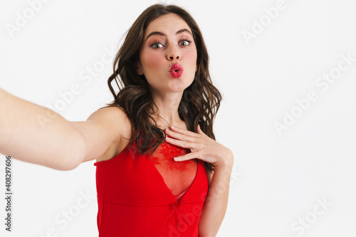 Surprised beautiful girl making kiss lips while taking selfie photo