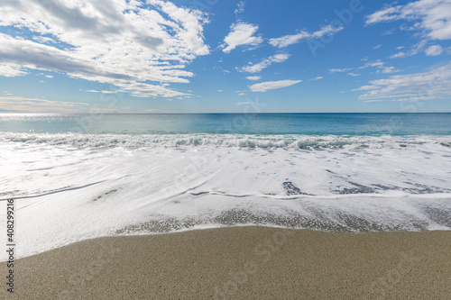 Blue sea water waves with white foam and bubbles washes the beach. Winter see. Riva Trigoso on ligurian coast photo