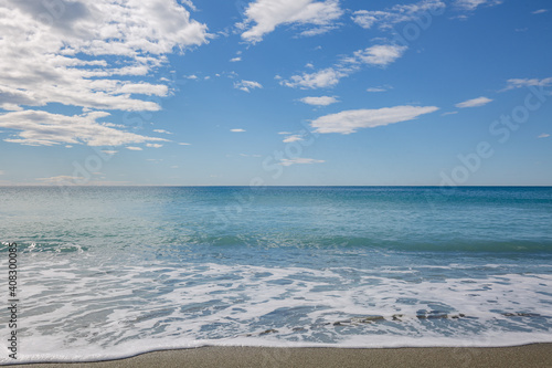 Blue sea water waves with white foam and bubbles washes the beach. Winter see. Riva Trigoso on ligurian coast