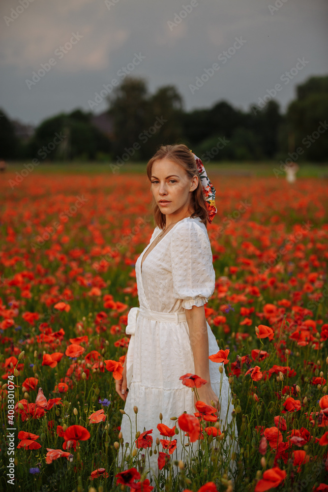 woman in white dress in a field of poppies woman in white dress in a field of poppies