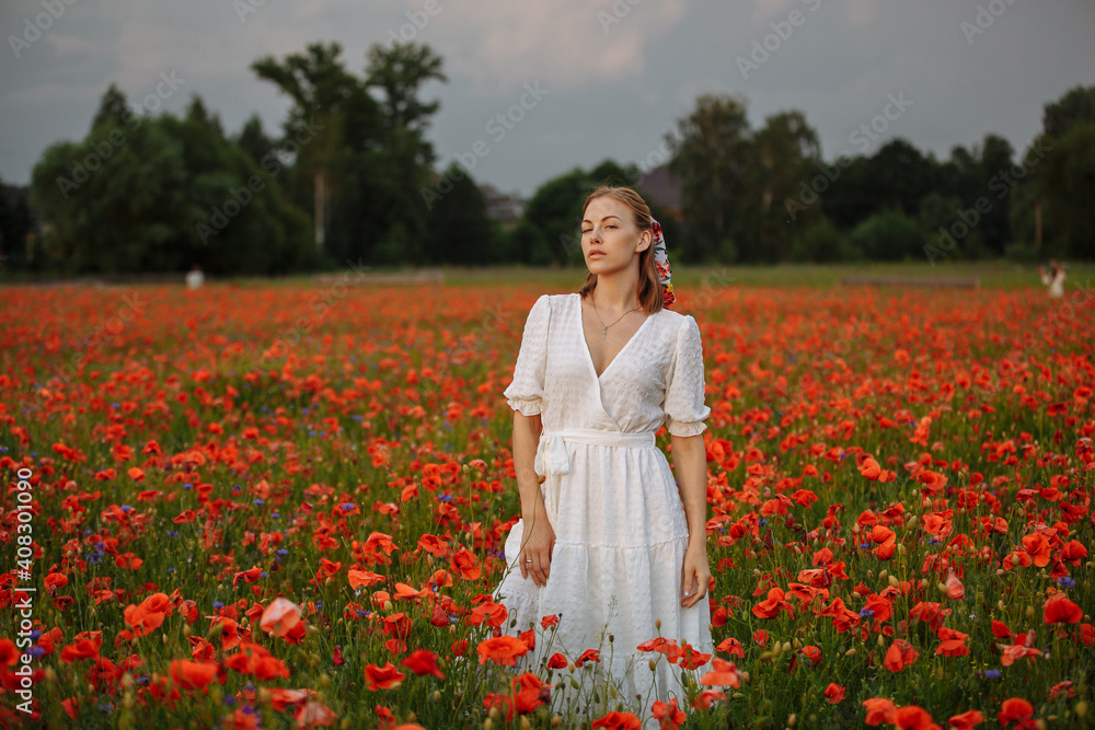 woman in white dress in a field of poppies woman in white dress in a field of poppies