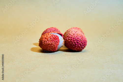 Ripe lychees on a beige background one open