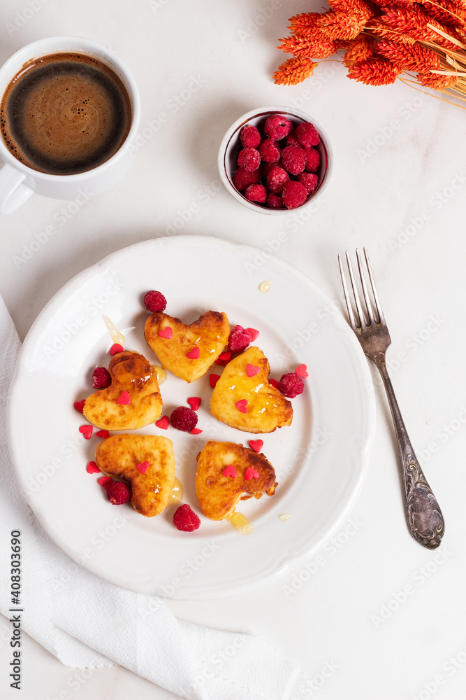 Breakfast on Valentine's Day - cheesecakes in the shape of hearts and red bouquet. Breakfast on Valentine's Day - cheesecakes in the shape of hearts and red bouquet.