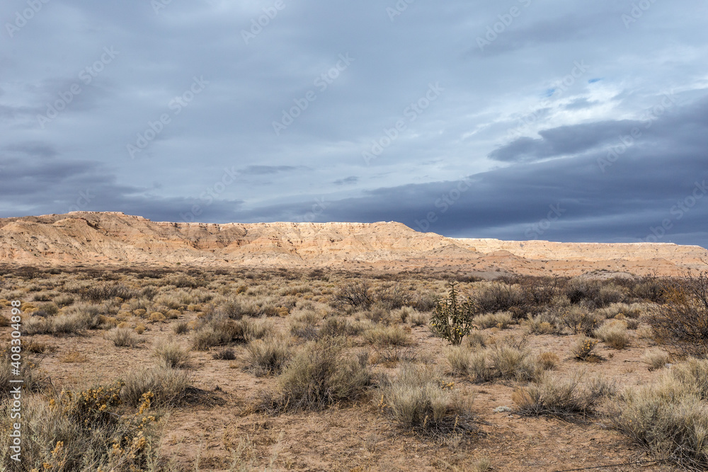 Beautiful blue sky with clouds behind mesa plateau in open desert range on cloudy day in rural New Mexico