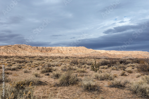 Beautiful blue sky with clouds behind mesa plateau in open desert range on cloudy day in rural New Mexico