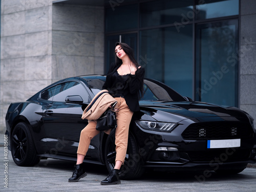 Woman stands near a sports car in the city © Sergii Mironenko