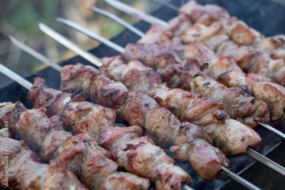 Roasted meat cooked at barbecue. Traditional eastern dish, shish kebab. Grilled kebab cooking on metal skewer. 
