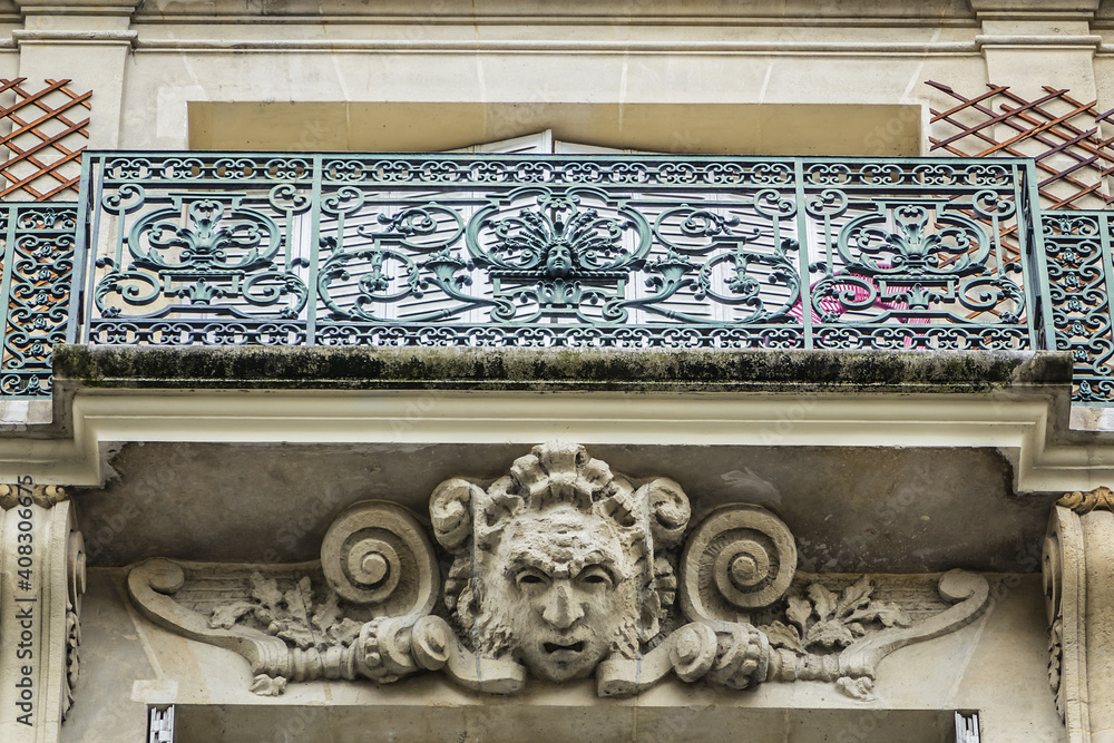 Traditional French house with typical balconies and windows. Paris, France.