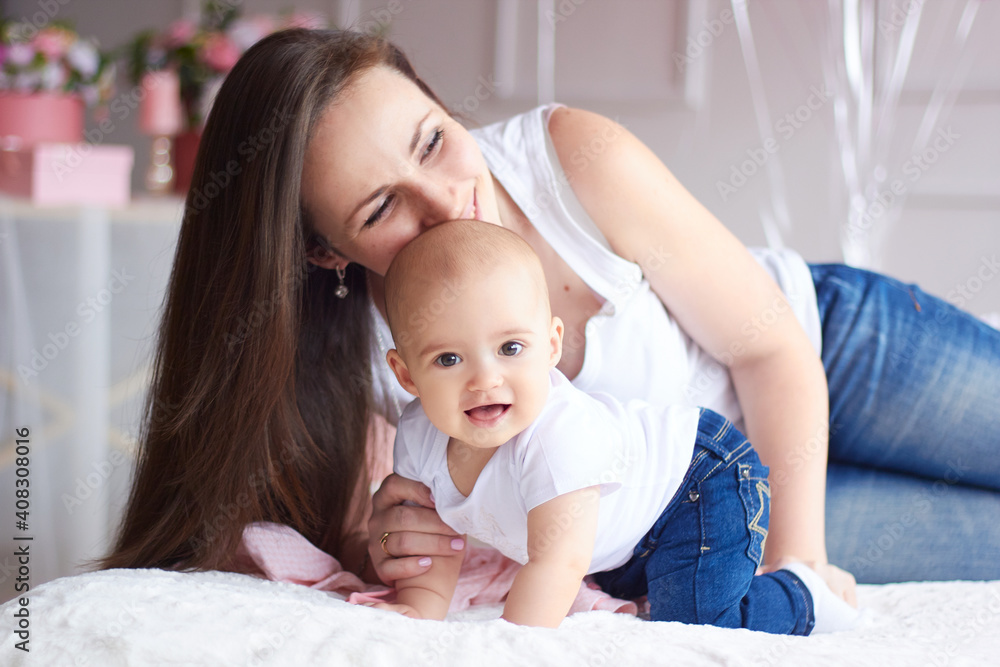 Happy family. Mother with her little baby in light interior livihg room. Mother's day celebration with gifts and flowers Happy family. Mother with her little baby in light interior livihg room. Mother's day celebration with gifts and flowers