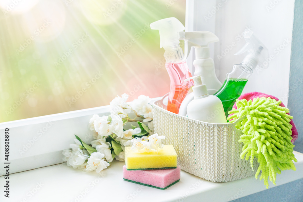 Spring cleaning concept - cleaning supplies and flowers on blur background, copy space - obrazy, fototapety, plakaty 