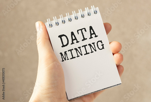 Business concept. Businessman holds a card with the text - DATA MINING