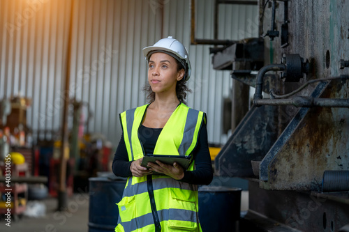 Factory female worker working and checking with clipboard in hands taking necessary notes at plant.