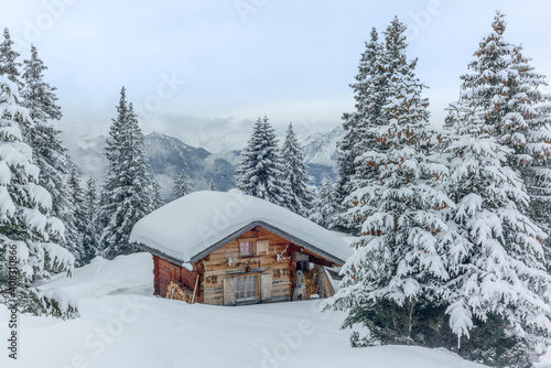 Isolated summer chalet and villages high up on the Swiss Alps covered in fresh powder snow near Davos © gdefilip